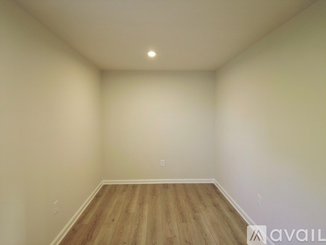 Empty room with wooden floor and white walls.
