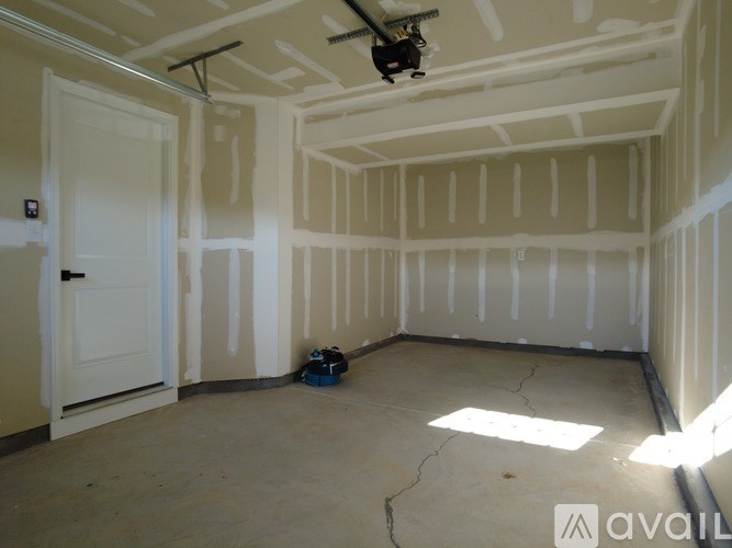 A room under construction with a ceiling fan and a door.