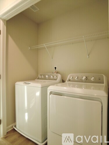 A white washing machine and dryer in a small laundry room.