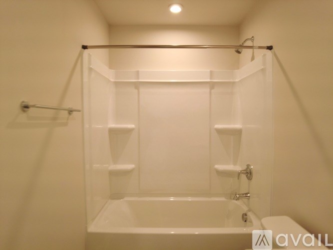A white bathroom with a tub and a towel rack.