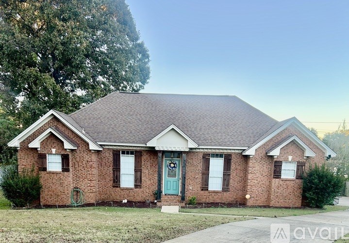 A brick house with a green door and a small front yard.