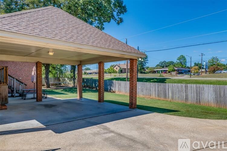 A covered patio area with a wooden roof and pillars.