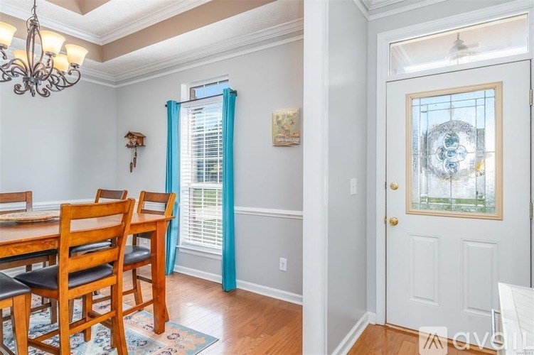 A dining room with a wooden table and chairs.