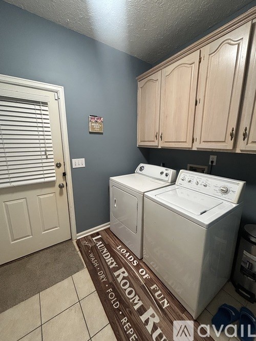A laundry room with a washer and dryer and a rug that says "Laundry Room Fun".