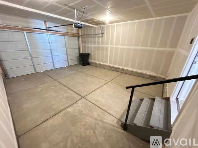 A spacious garage with a staircase leading to the second floor.