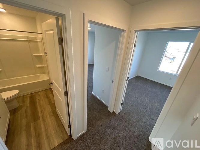 A small, empty room with a carpeted floor and a window.
