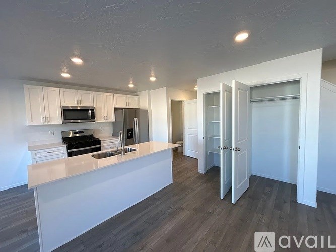 A kitchen with white cabinets and a countertop is available for rent.
