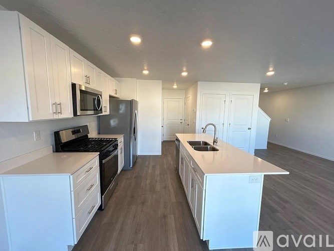 A kitchen with white cabinets and a wooden floor.