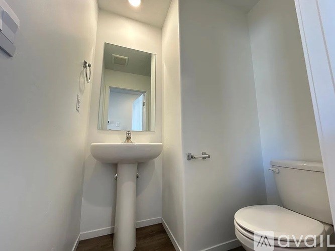 A white bathroom with a sink, toilet and mirror.