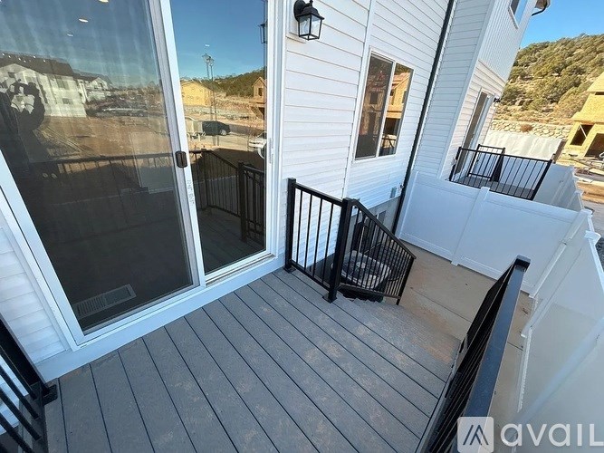 A balcony with a black railing and a glass door.