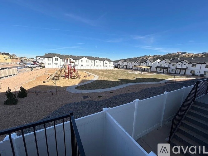 A view from a balcony overlooking a playground and apartment buildings.