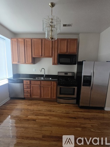 A kitchen with wooden cabinets and a chandelier.