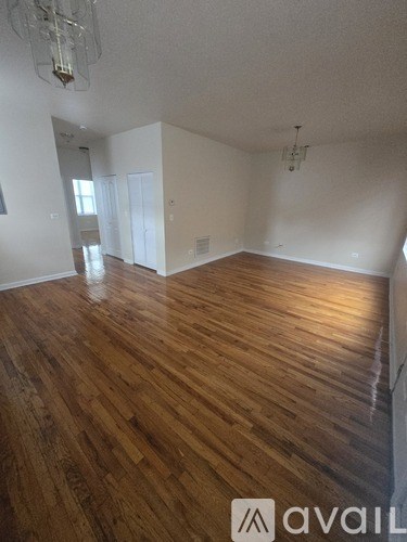 A room with wooden floors and a chandelier.