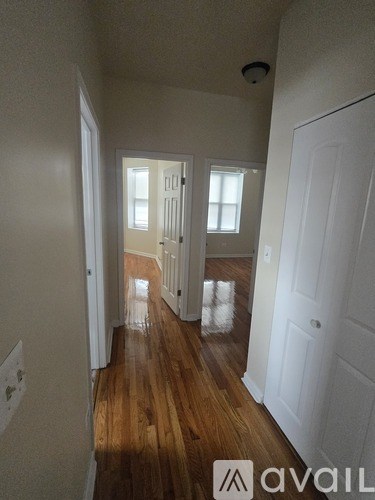 A hallway with wooden floors and white walls.