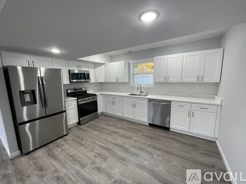 A modern kitchen with stainless steel appliances and white cabinets.
