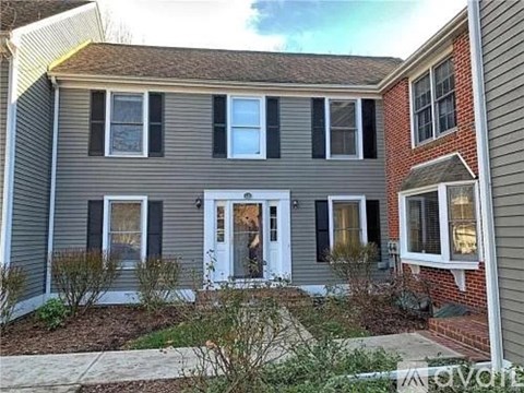 A house with a grey siding and a white door is shown.