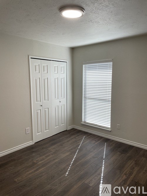A room with a white door and a window with blinds.