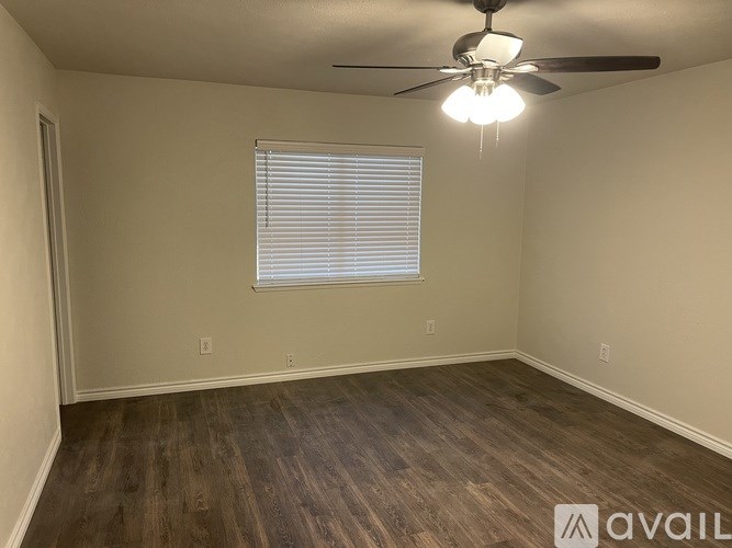 Empty room with a ceiling fan and a window with blinds.