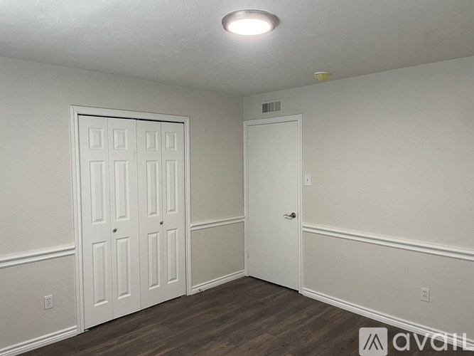 A room with two doors and a wooden floor.