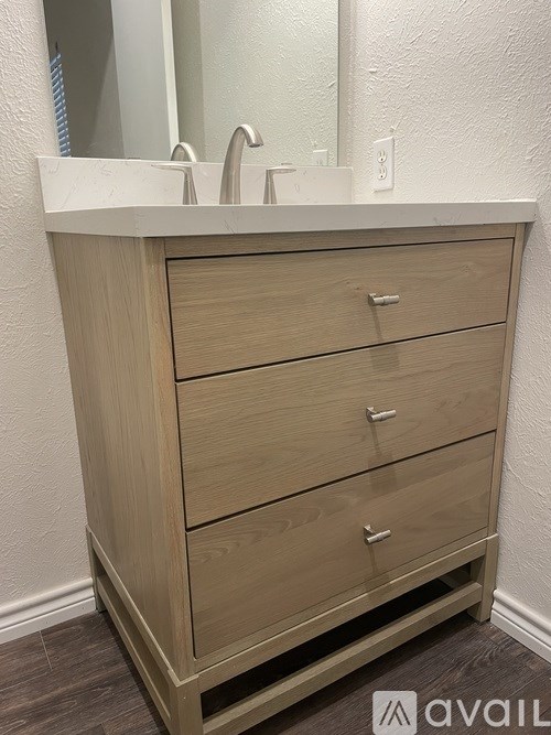 A bathroom vanity with a sink and three drawers.