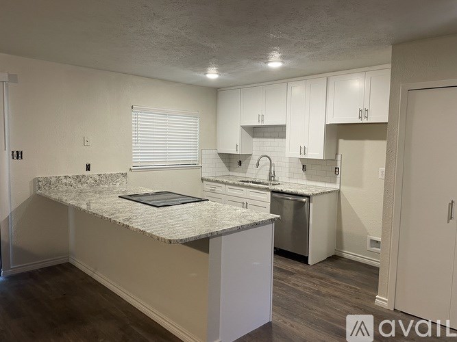 A kitchen with a marble countertop and white cabinets.