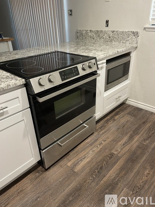 A kitchen with a granite countertop and a stove top oven.