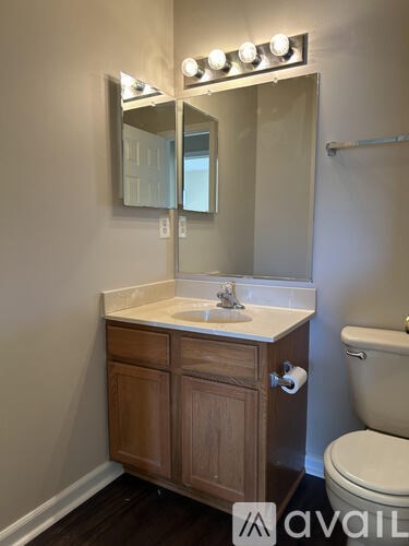 A bathroom with a sink, mirror, and toilet.