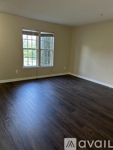 A room with a large window and wooden flooring.