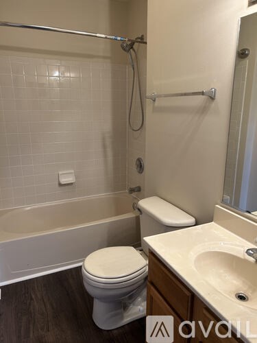 A white toilet sits next to a bathtub in a bathroom.