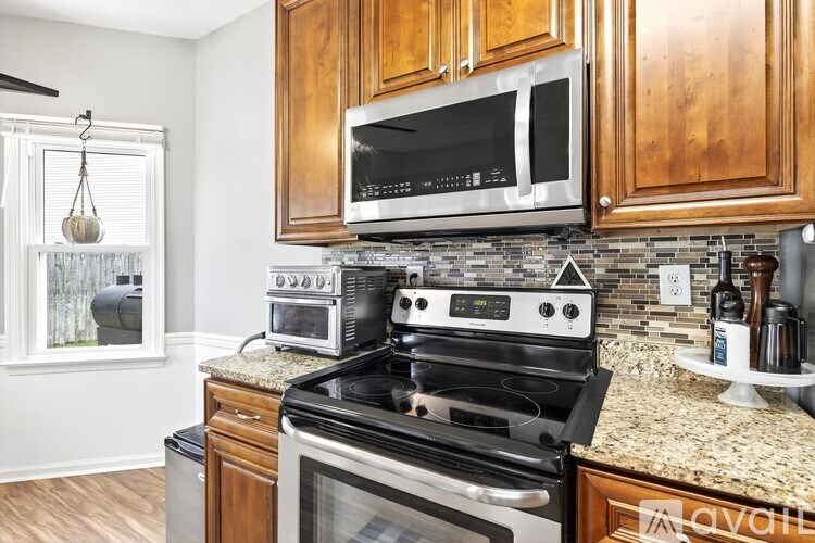 A kitchen with a black stove top oven and a black microwave above it.