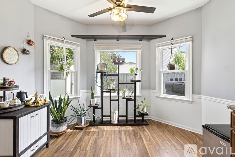 A living room with a ceiling fan and a wooden floor.