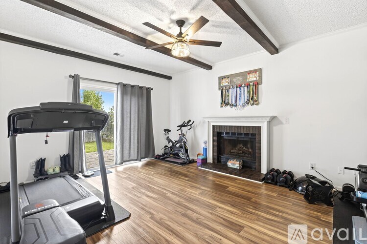 A room with a treadmill, a fireplace, and exercise equipment.