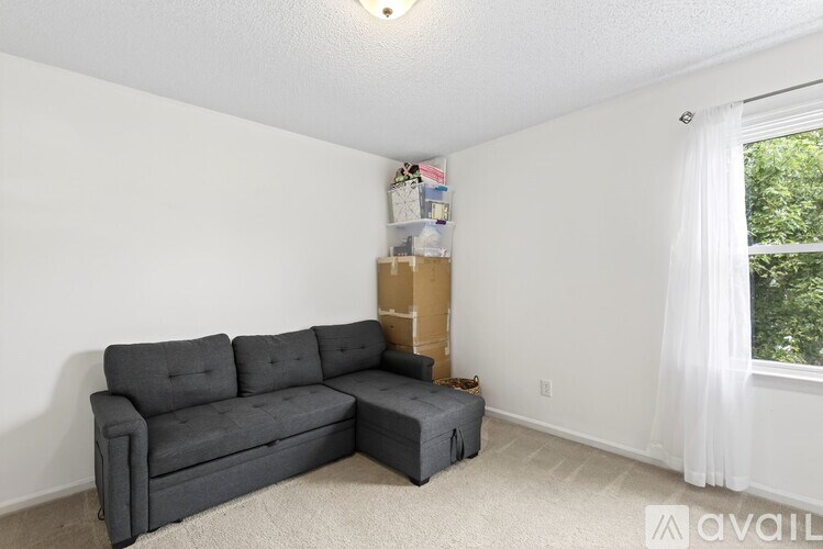 A grey sectional sofa with ottoman in a living room.