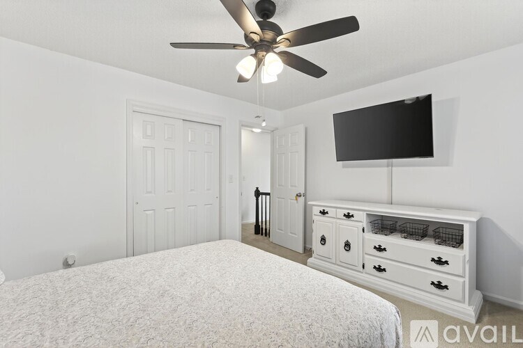 A bedroom with a bed, dresser, and television.