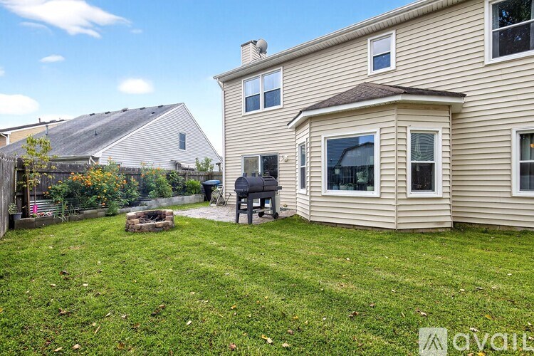 A house with a backyard and a fire pit.