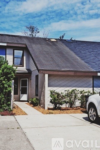 A house with a grey roof and a white door is shown.