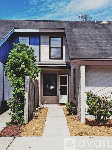 A house numbered 742 with a front yard and a sidewalk.