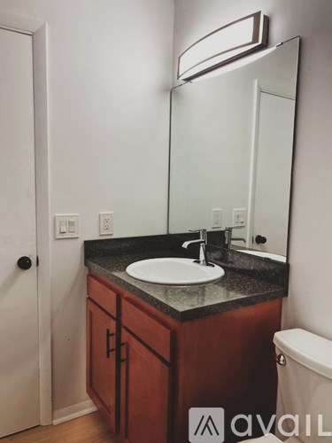 A bathroom with a sink, mirror, and toilet.