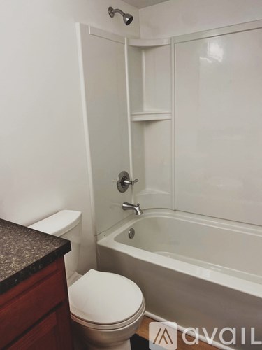 A white toilet sits next to a bathtub in a bathroom.