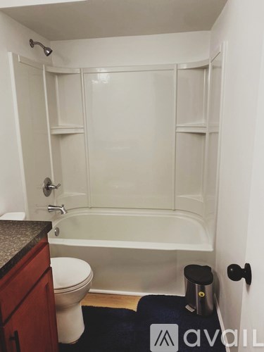 A bathroom with a toilet, a bathtub, and a towel rack.