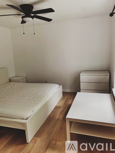 A bedroom with a bed, nightstand, and a table.