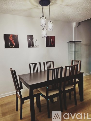A dining room with a table and chairs.