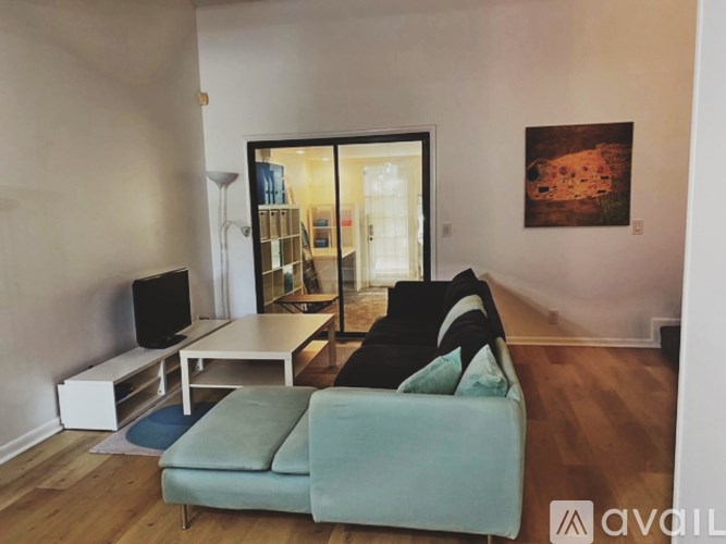 A living room with a couch, a television, and a painting on the wall.