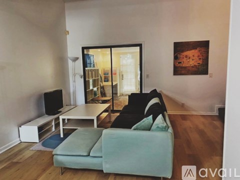 A living room with a couch, a television, and a painting on the wall.