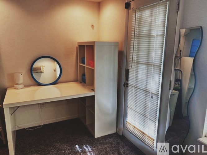 A bathroom with a mirror, sink, and a cabinet.