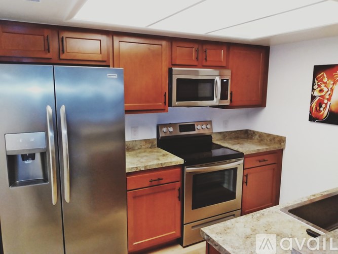 A kitchen with a stainless steel refrigerator, microwave, and oven.