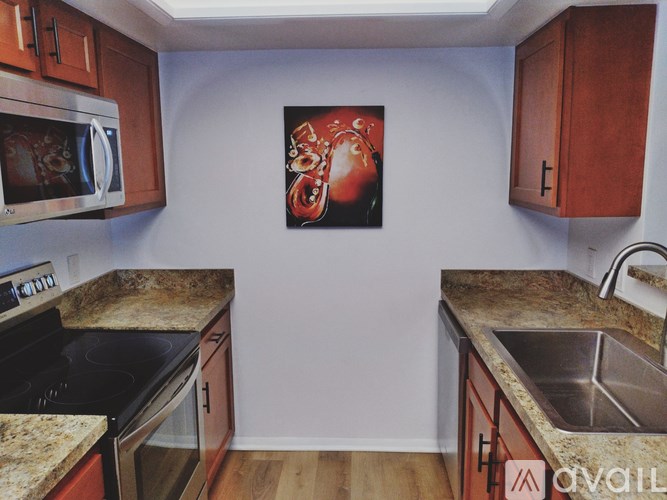 A kitchen with a painting hanging on the wall.