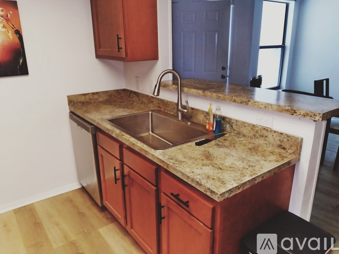A kitchen with a granite countertop and wooden cabinets.