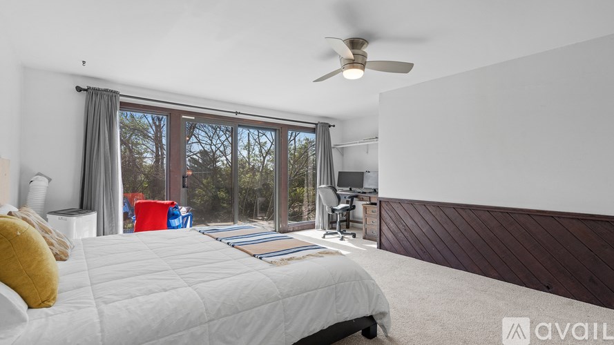 A bedroom with a large bed and a ceiling fan.
