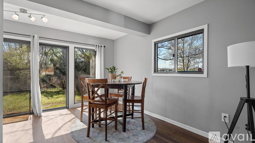 A dining room with a table and chairs and a window.